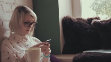 mutlu genç güzel kadın akıllı telefonunu kafe ve manifatura kahve içme