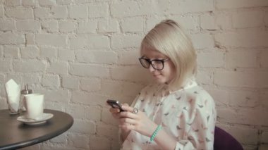 mutlu genç güzel kadın akıllı telefonunu kafe ve manifatura kahve içme