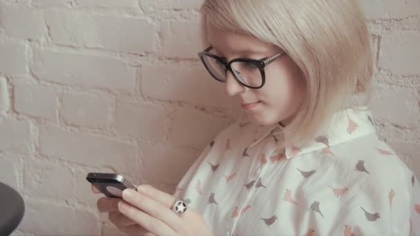 快乐年轻漂亮的女人在她的智能手机上喝咖啡在咖啡馆和发短信 — 图库视频影像