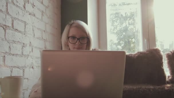 Gelukkig jonge mooie vrouw bezig met haar laptop in het café — Stockvideo
