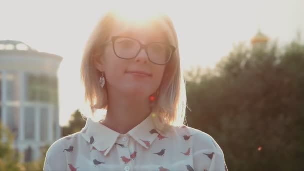 Προσωπογραφία της μια ελκυστική γυναίκα στο πάρκο της πόλης με ήλιο να λάμπει στο παρασκήνιο — Αρχείο Βίντεο