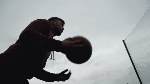 Genç adam açık havada sahada basket oynarken — Stok video
