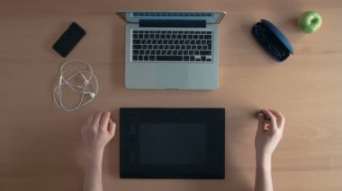 En iyi tasarımcı adam veya Illustrator kullanır onun grafik tablet ve dizüstü eğleniyor etrafında dalga dijital tasarım oluşturma görünüm onun parmaklarıyla oynamak