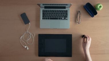Üstten Görünüm Tasarımcısı adam veya Illustrator gözlüklerini masaya koyar grafik tablet ve dijital tasarım oluşturma dizüstü kullanır