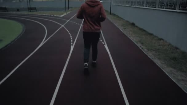 Joven corriendo en la pista siguiente disparo — Vídeos de Stock