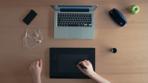 Top view designer homme ou illustrateur utilise sa tablette graphique et ordinateur portable créant un design numérique 