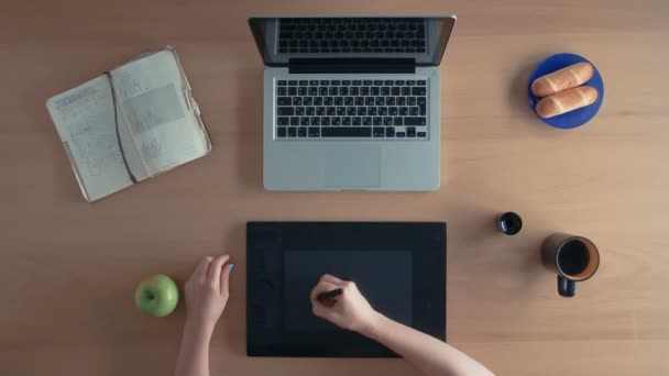 Το Top view σχεδιαστής γυναίκα ή illustrator χρησιμοποιεί το tablet γραφικών και φορητό υπολογιστή, δημιουργία ψηφιακού σχεδιασμού drinknig καφέ και τρώει ένα μήλο — Αρχείο Βίντεο