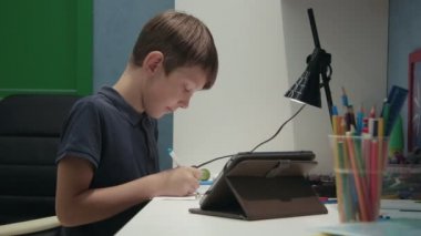 Genç çocuk dijital tablet kopyalama bir resim çizim