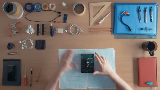 Techniker von oben arbeitet an Festplatte auf seinem Schreibtisch voller Geräte — Stockvideo