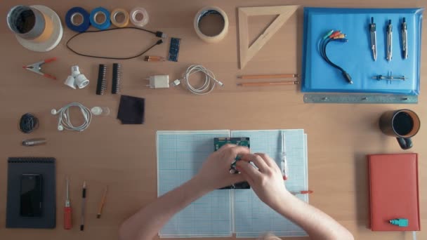 Techniker von oben arbeitet an Festplatte auf seinem Schreibtisch voller Geräte — Stockvideo