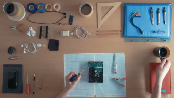 Techniker von oben arbeitet an Festplatte auf seinem Schreibtisch voller Geräte — Stockvideo