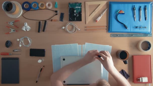 Engenheiro técnico de visão superior está reparando computador portátil em sua mesa cercada por suprimentos e equipamentos — Vídeo de Stock