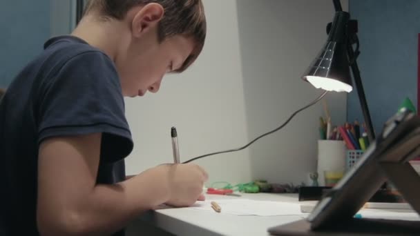 Jeune garçon dessinant une image le copiant à partir d'une tablette numérique — Video