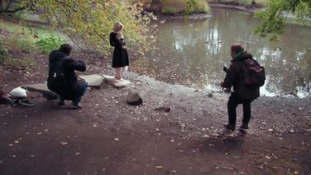 Fotoshooting einer jungen Frau im Charakter eines beängstigend weißen Mädchens mit einer Puppe in einem Teich — Stockvideo