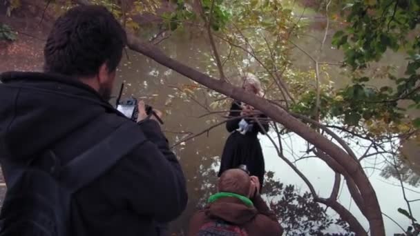 Fotoshooting einer jungen Frau im Charakter eines beängstigend weißen Mädchens mit einer Puppe in einem Teich — Stockvideo