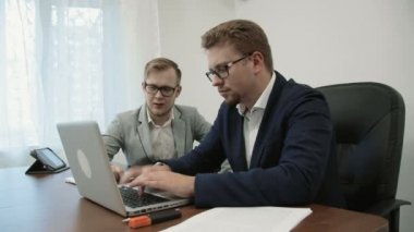 Birlikte laptop ekrana bakarak ve yazarak, daha başarılı ve onların zaferini kutluyor çalışma iki başarılı iş adamları