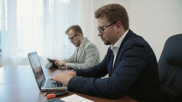 Dois jovens empresários que trabalham no escritório de espaço aberto realmente duro e intenso — Vídeo de Stock