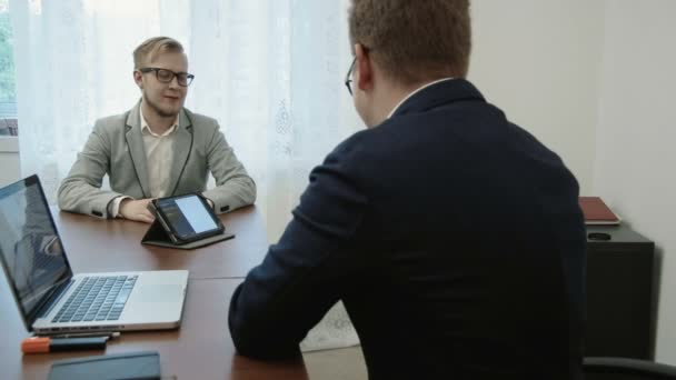 El hombre está tomando una entrevista de trabajo y mostrando su curriculum vitae y hablando de sus conocimientos y experiencia — Vídeos de Stock