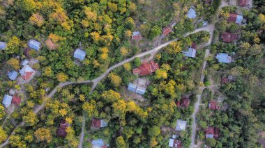 Bir hava aracı dağlık kırsal vadi boyunca yayılan mevsimsel yangını yakalıyor. Ormandaki tepeler parlak kehribar, altın ve kırmızı tonlarda parlayarak koyu yeşil kozalaklı ağaçlarla çarpıcı bir kontrast oluşturuyor.
