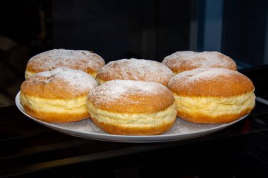 Bir fırının tezgahında birkaç kremalı çörek tabağı..