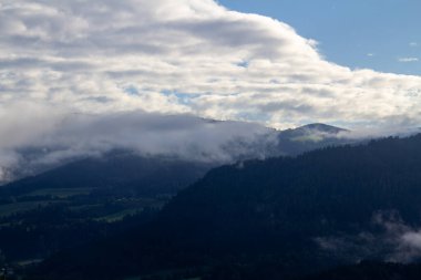 Vistara, Carinthia 'daki Avusturya dağlarının üzerinde. Fotoğraf güneş doğduktan hemen sonra çekildi. Bulutlar vadiden dağlara doğru hareket ediyor..