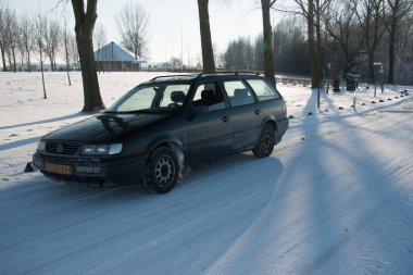 Hollanda 'da kar altında klasik siyah VW Passat. Fotoğraf 4 Şubat 2012 'de Hollanda' da Tiel 'de çekildi. Bu öge sadece editörler içindir.