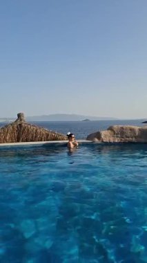 Deniz kenarında serinletici bir içkinin tadını çıkarırken güzel bir sahil bölgesinde havuzda dinleniyorum.