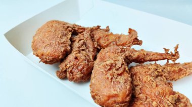 Beyaz yemek tepsisinde dört kızarmış tavuk kanadı