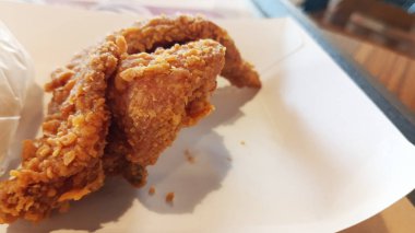 Beyaz kağıt tabakta kızarmış tavuk kanadı.