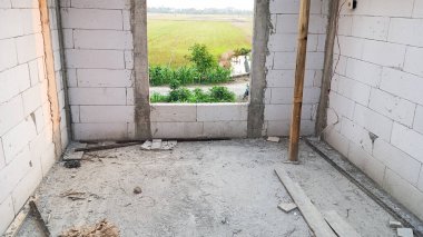 Duvarları beyaz tuğlalardan yapılmış, yapım aşamasındaki bir odanın içinde.