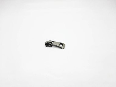 Metal fermuar kaydırma parçası, küçük işlevsel donanım tasarım elementini vurgulayarak, beyaz bir arkaplanda izole bir şekilde yatar..