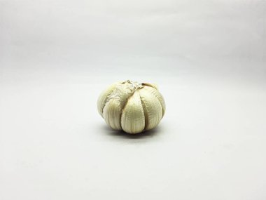 Tek bir sarımsak ampulü, besin kavramları için dokusunu ve şeklini vurgulayan parlak beyaz bir yüzeye odaklanmıştır..