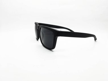 Siyah modern güneş gözlükleri, saf beyaz bir arka planda, temiz bir stüdyo çekiminde siyah lensleri ve çerçeve şeklini gösteren yatay olarak sergilenir..