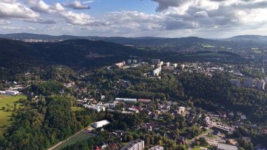 This stunning aerial view showcases breathtaking mountains and residential areas under a picturesque sky