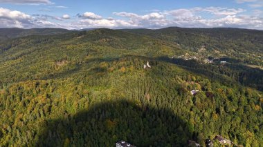 Mesmerizing aerial footage beautifully showcasing the lush green hills alongside vibrant autumn foliage and colors