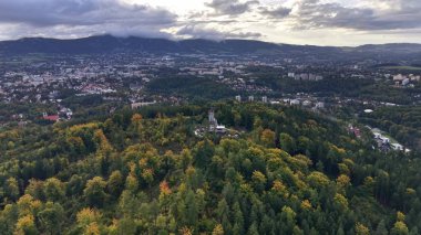 This aerial photograph captures a breathtaking view of vibrant autumn foliage alongside the urban scenery