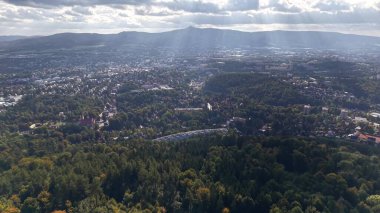 Stunning aerial shot beautifully capturing a vibrant cityscape adorned with lush greenery and dramatic skies