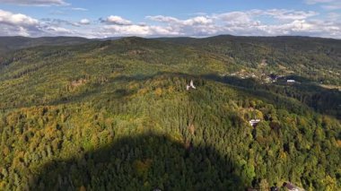 Mesmerizing aerial footage beautifully showcasing the lush green hills alongside vibrant autumn foliage and colors
