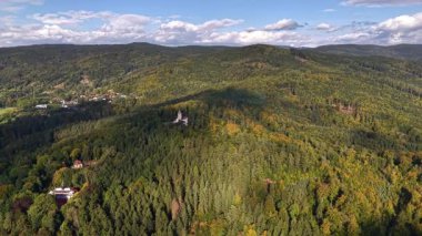 Stunning drone footage beautifully showcases colorful forested hills alongside a peaceful and charming village