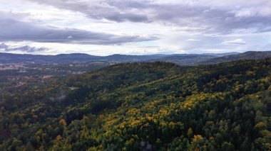 Incredibly breathtaking aerial shot capturing vibrant and lush forested hills situated beneath a dramatic sky
