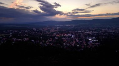 Captivating aerial view of a stunning city at sunset, featuring vibrant clouds and a peaceful landscape