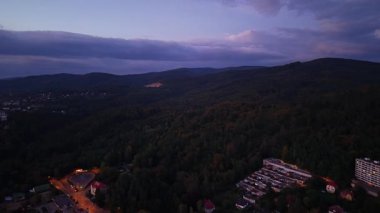 Orman ve güzel renkli günbatımı ile dağ manzarası üzerinde hava görüntüsü