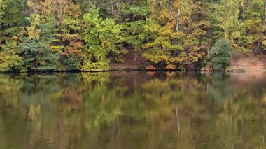Capture autumn colors mirrored on still waters, showcasing natures serene elegance and tranquility