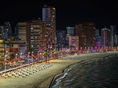 Gece gezintisi yansımalarla dolu, akşam şehir manzarası neon ışıklarıyla aydınlatılmış ve yumuşak sörf