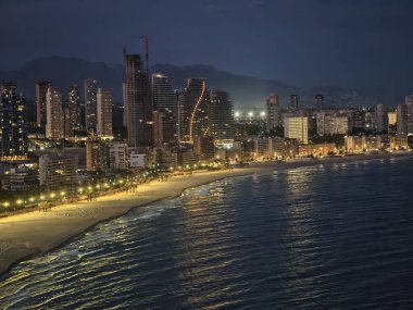 Turnalar ve aydınlatma ile şehir manzarası, devam eden inşaat faaliyetleri sırasında gökyüzü aydınlanıyor