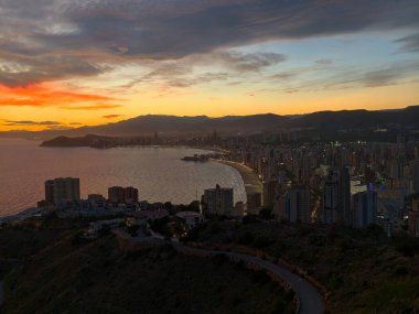 Altın akşam gökyüzü altında sakin bir kıyı şeridi. Parlak günbatımını aydınlatan görkemli kıyı manzarası.