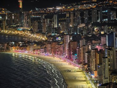 Canlı kentsel ufuk çizgisi sakin suları renkli yansımalar ve canlı atmosferle aydınlatıyor.