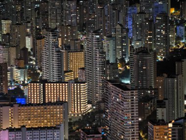 Canlı kentsel ufuk çizgisi sakin suları renkli yansımalar ve canlı atmosferle aydınlatıyor.