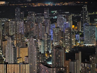 Canlı kentsel ufuk çizgisi sakin suları renkli yansımalar ve canlı atmosferle aydınlatıyor.