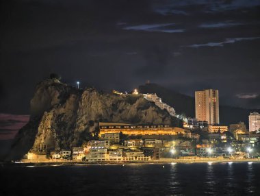 Canlı kentsel ufuk çizgisi sakin suları renkli yansımalar ve canlı atmosferle aydınlatıyor.